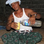 Balinese guy pouring arak